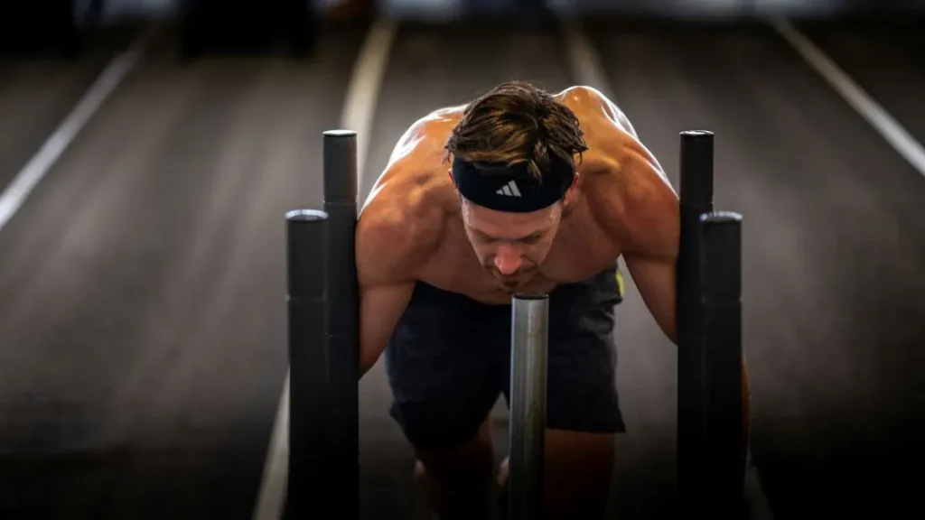 Atleta practicando ejercicios funcionales de alta intensidad y fuerza útil en un centro de entrenamiento