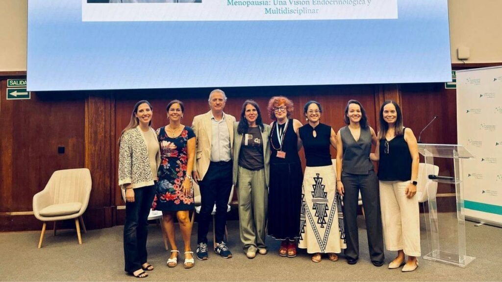 Médico especialista revisando estudios clínicos de densidad ósea y perfil cardiovascular en paciente durante la transición menopáusica