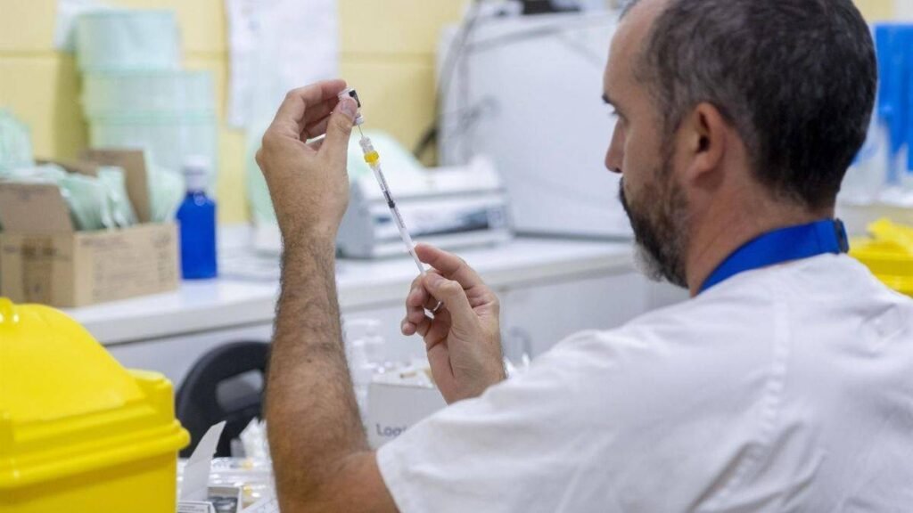 Personal médico administrando una dosis de vacuna antigripal a un paciente pediátrico en un entorno clínico seguro.